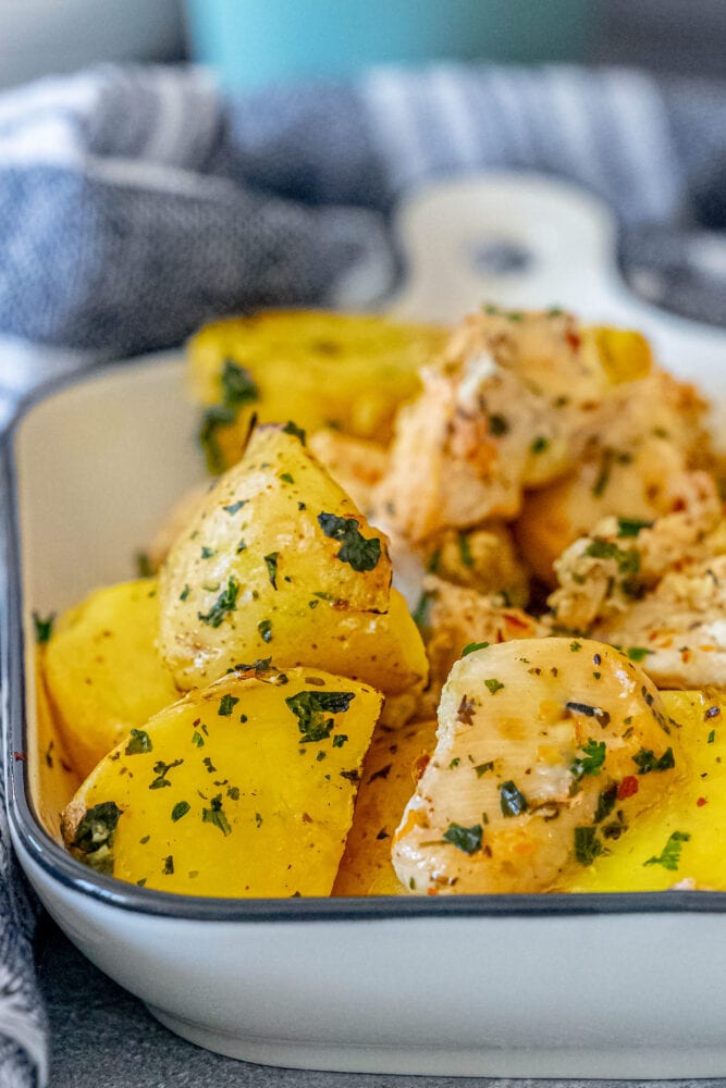lemon garlic chicken and potatoes in a white dish 