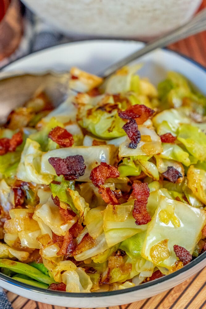 fried cabbage and crispy bacon in a white bowl 