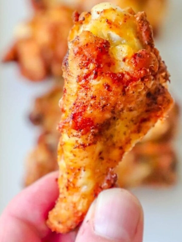 a hand holding a chicken wing seasoned with cajun seasoning