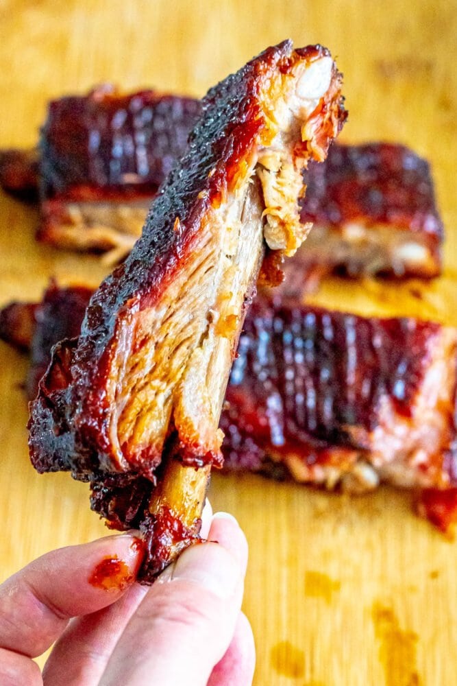 picture of a hand holding smoked pork ribs