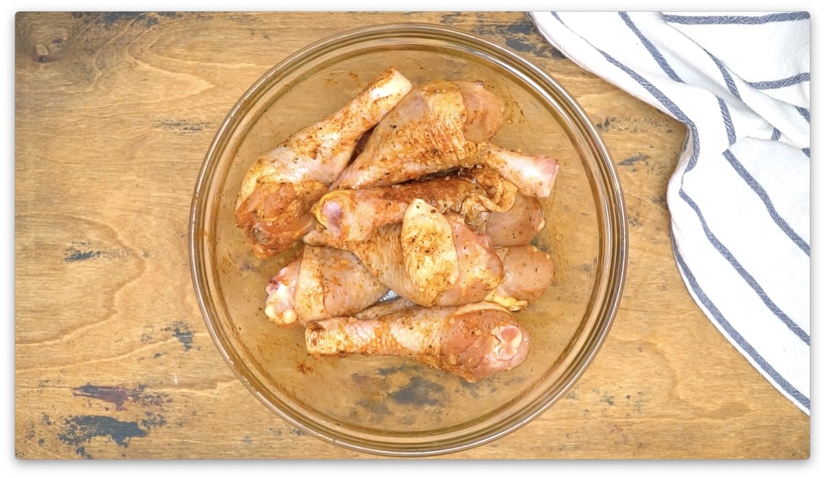 Easy air-fried chicken thighs in a glass bowl on a wooden table.