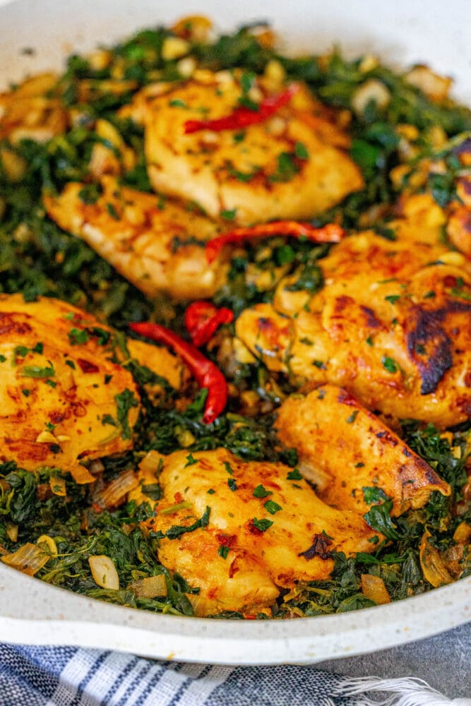 picture of harissa chicken and spinach in a pan 