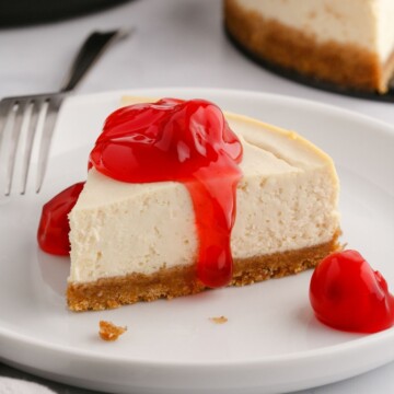 picture of a slice of cherry cheesecake on a white plate