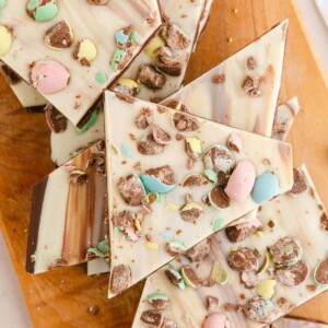 picture of white chocolate and chocolate layered easter bark with cadbury mini eggs on a wood cutting board