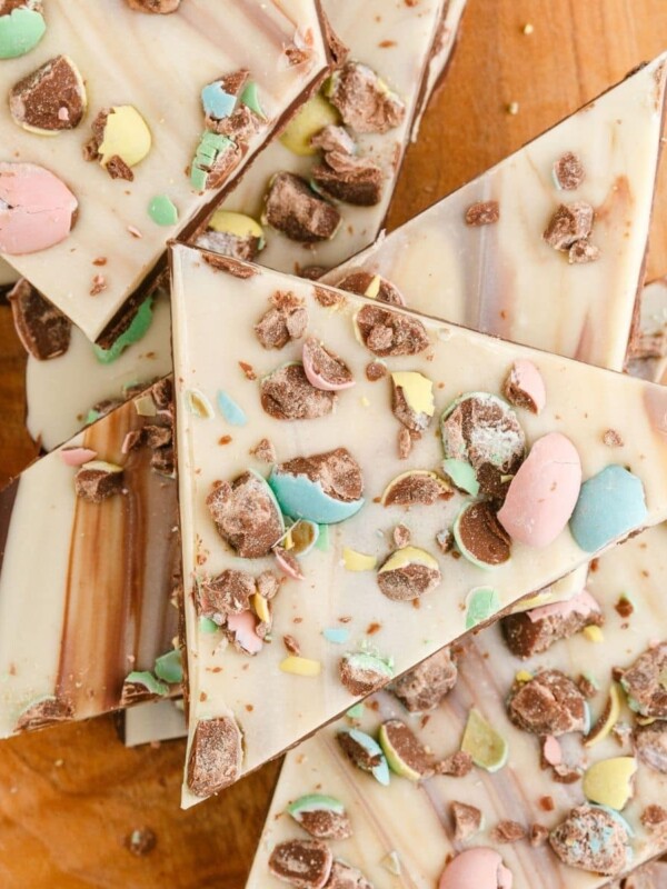 picture of white chocolate and chocolate layered easter bark with cadbury mini eggs on a wood cutting board