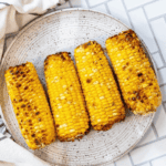 The best grilled corn on the cob recipe, beautifully presented on a plate.