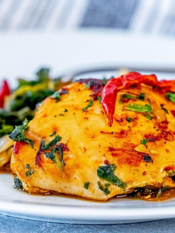 picture of harissa chicken and spinach on a white plate