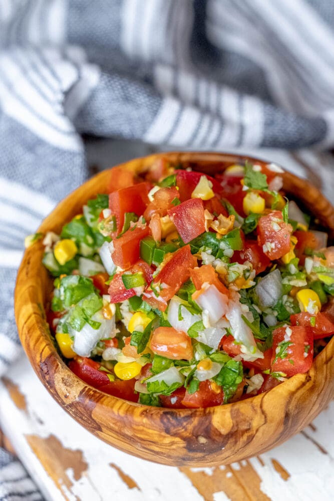 picture of corn pico de gallo in a wooden bowl 