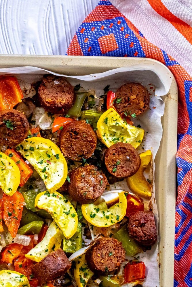 picture of baked vegan chorizo sausage, squash, peppers, onions, and mushrooms on a baking sheet