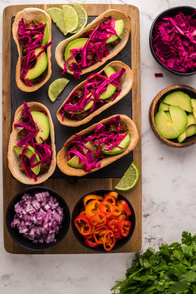 picture of air fried tofu taco on a table topped with avocado peppers and cabbage