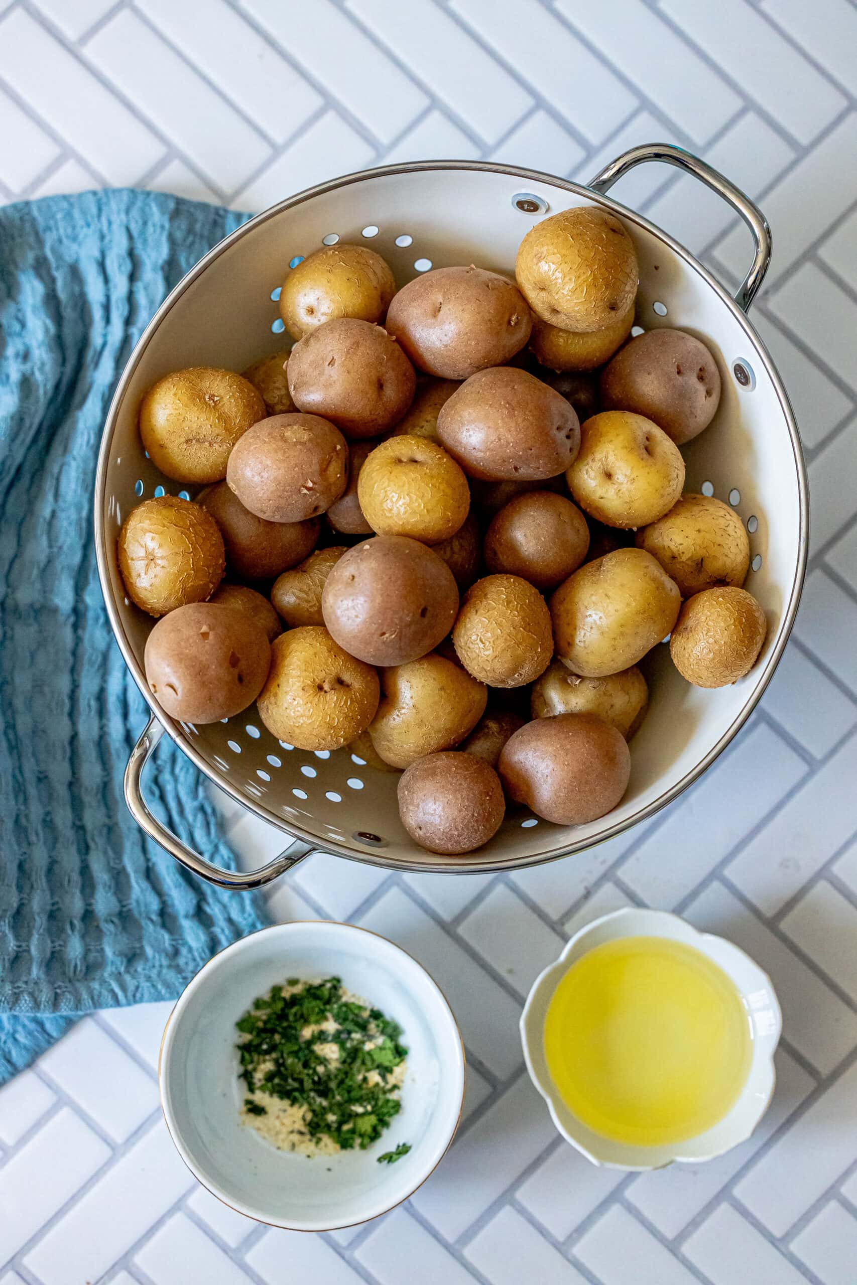 picture of potatoes in a colander with oil and spices