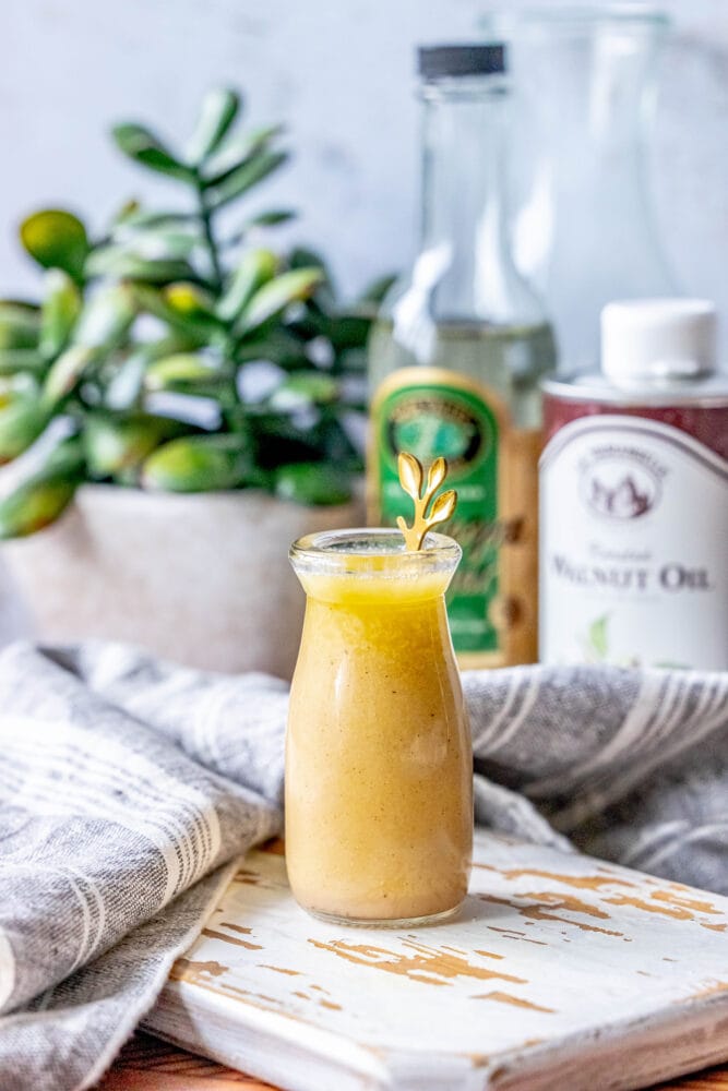 picture of champagne vinaigrette in a bottle with a gold spoon in it