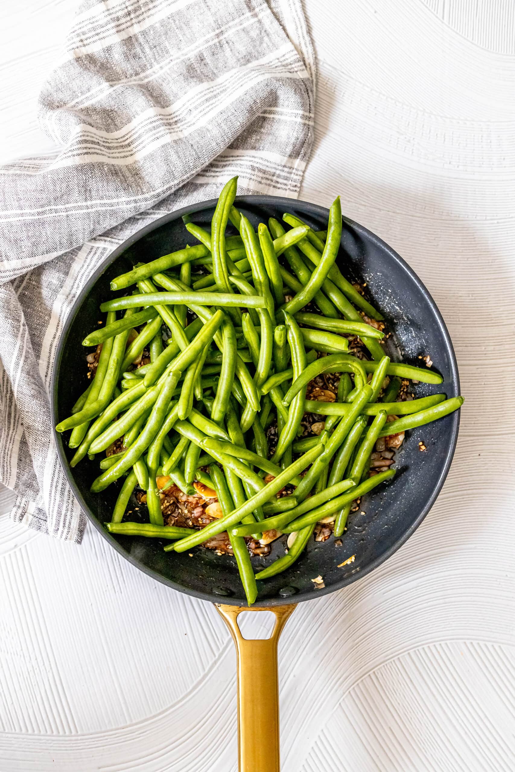 picture of green beans, shallots, and garlic in a pan