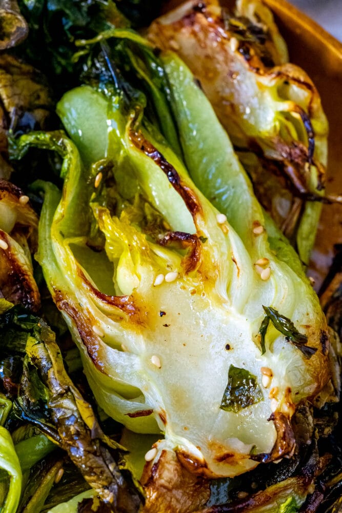 picture of grilled bok choy on a wood plate with sesame seeds 