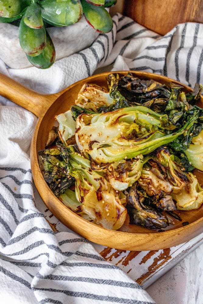 picture of grilled bok choy on a wood platter on a table