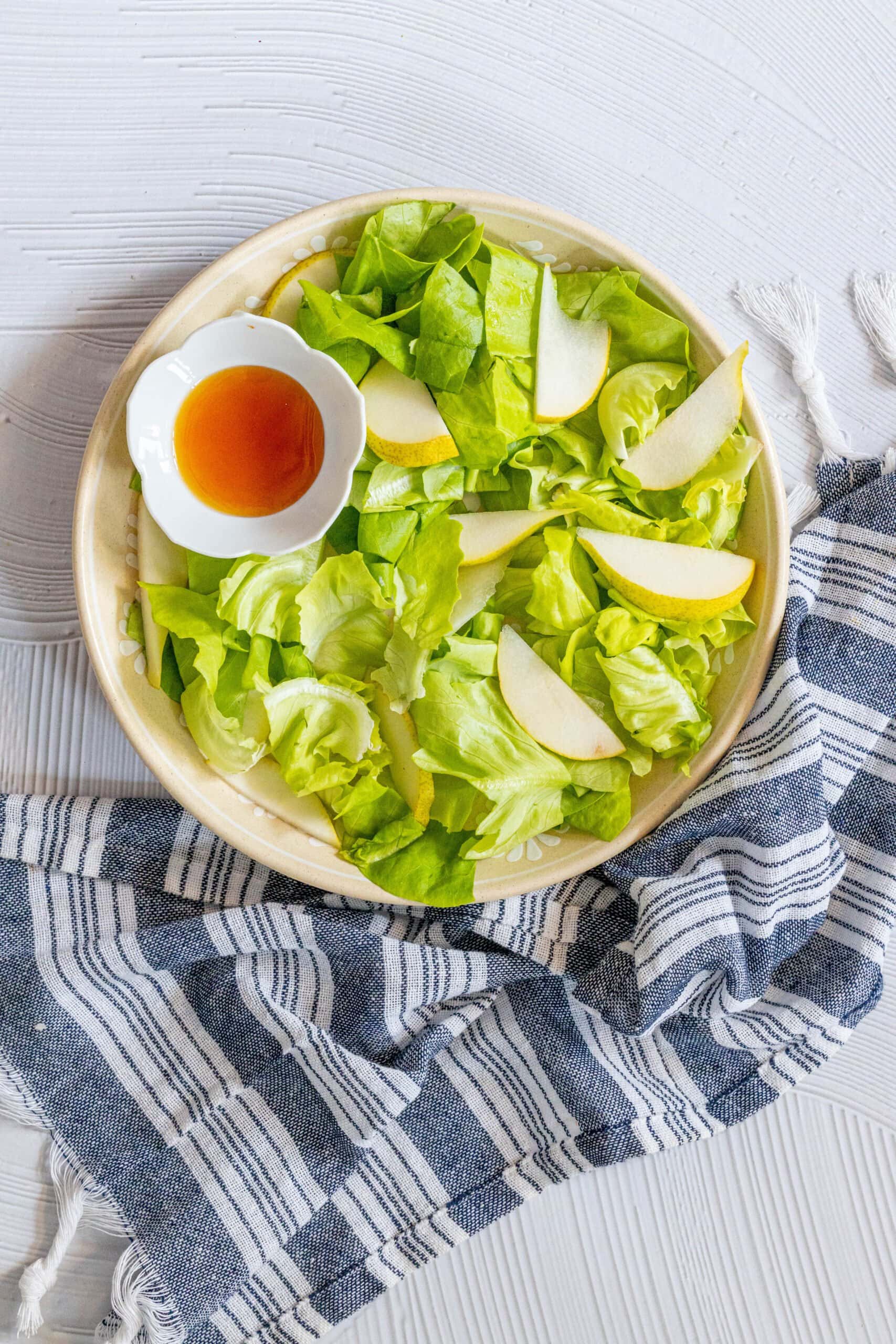 picture of butter lettuce and sliced pear in a bowl