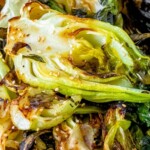 picture of grilled bok choy with sesame seeds on a wooden plate