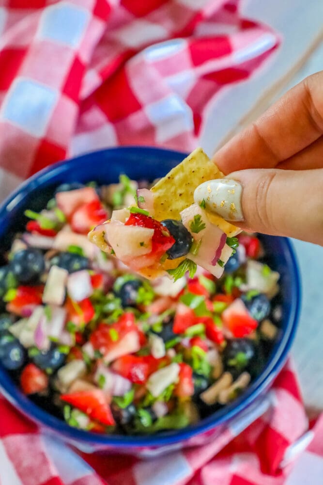 red white and blue fruit salsa in a bowl with cilantro and red onion