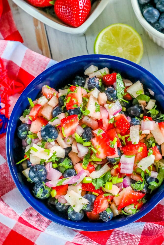 picture of red white and blue fruit salsa in a bowl with cilantro and red onion
