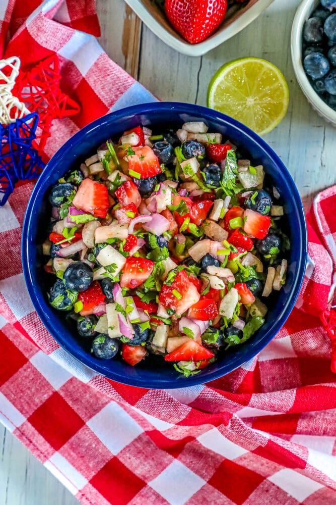 picture of red white and blue fruit salsa in a bowl with cilantro and red onion