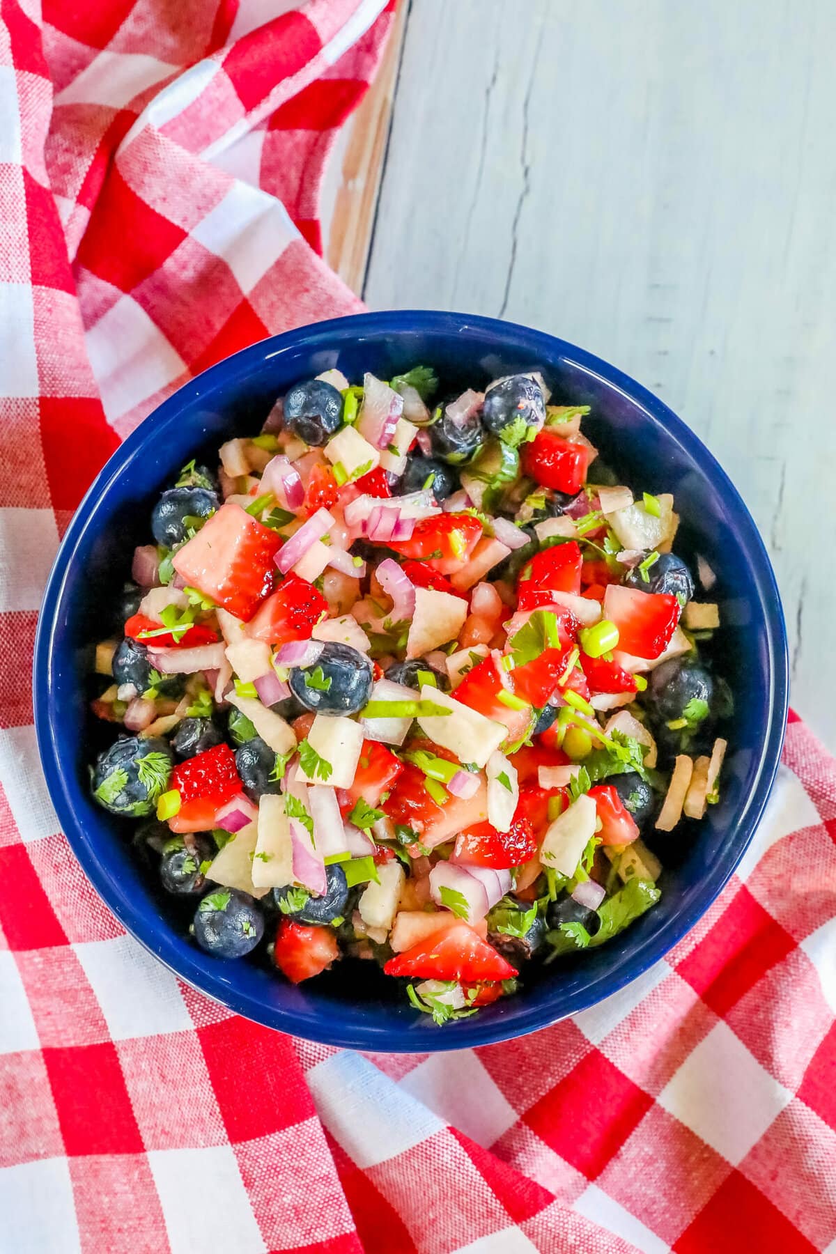 red white and blue fruit salsa in a bowl with cilantro and red onion