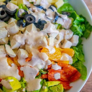 A salad with chicken, oranges, olives and dressing transformed into Aspen Village Salad with Southwestern Cumin Dressing.