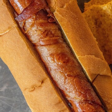 picture of bacon-wrapped hot dog in a hot dog bun