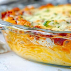 picture of baked spaghetti pie in a glass dish topped with cheese on a table