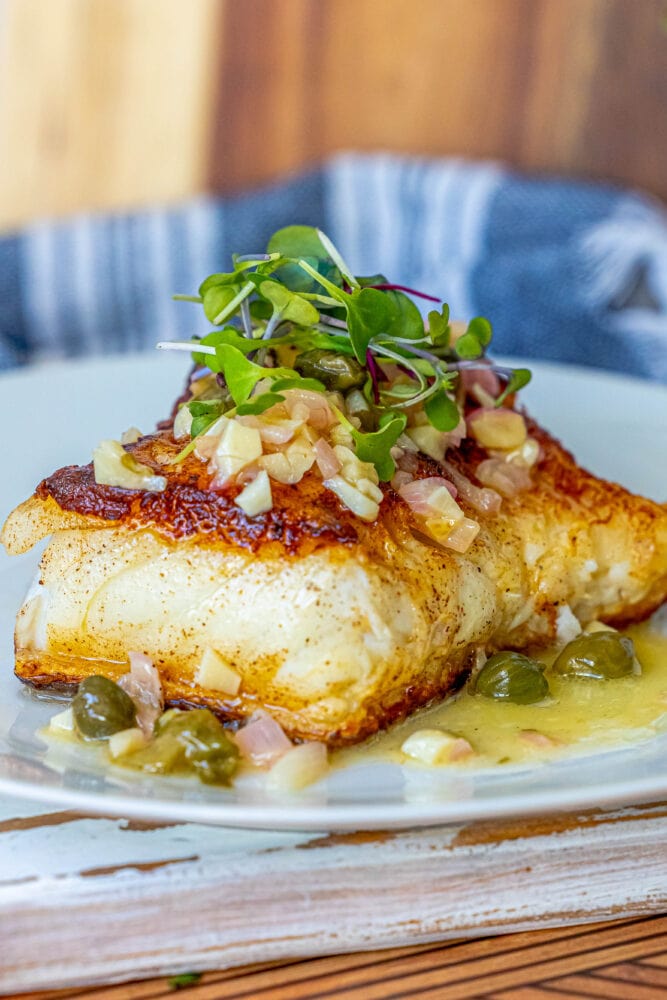 picture of chilean seabass with lemon caper butter on a plate with a fork 