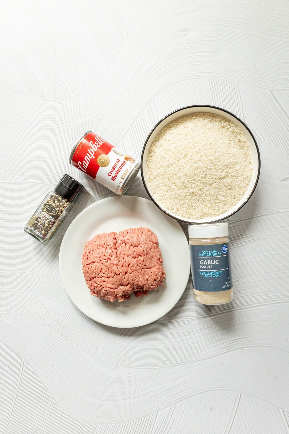 picture of pepper, a can of cream of mushroom soup, rice, meat, and garlic powder on a table