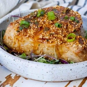 picture of tuna steak on white plate with sesame seeds and sauce on top