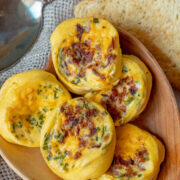 Instant Pot Egg Bites Recipe with bacon and cheese served on a wooden plate.
