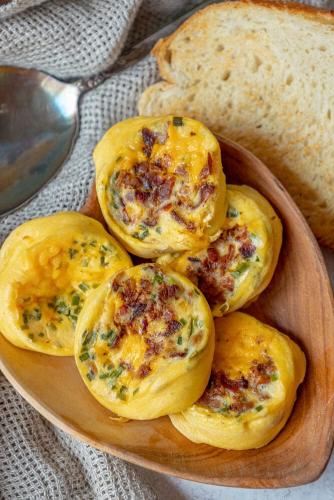 5 egg bites with bacon and chives bread in the background
