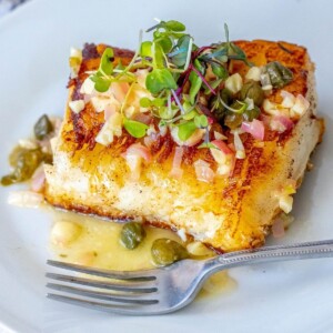 picture of chilean seabass with lemon caper butter on a plate with a fork
