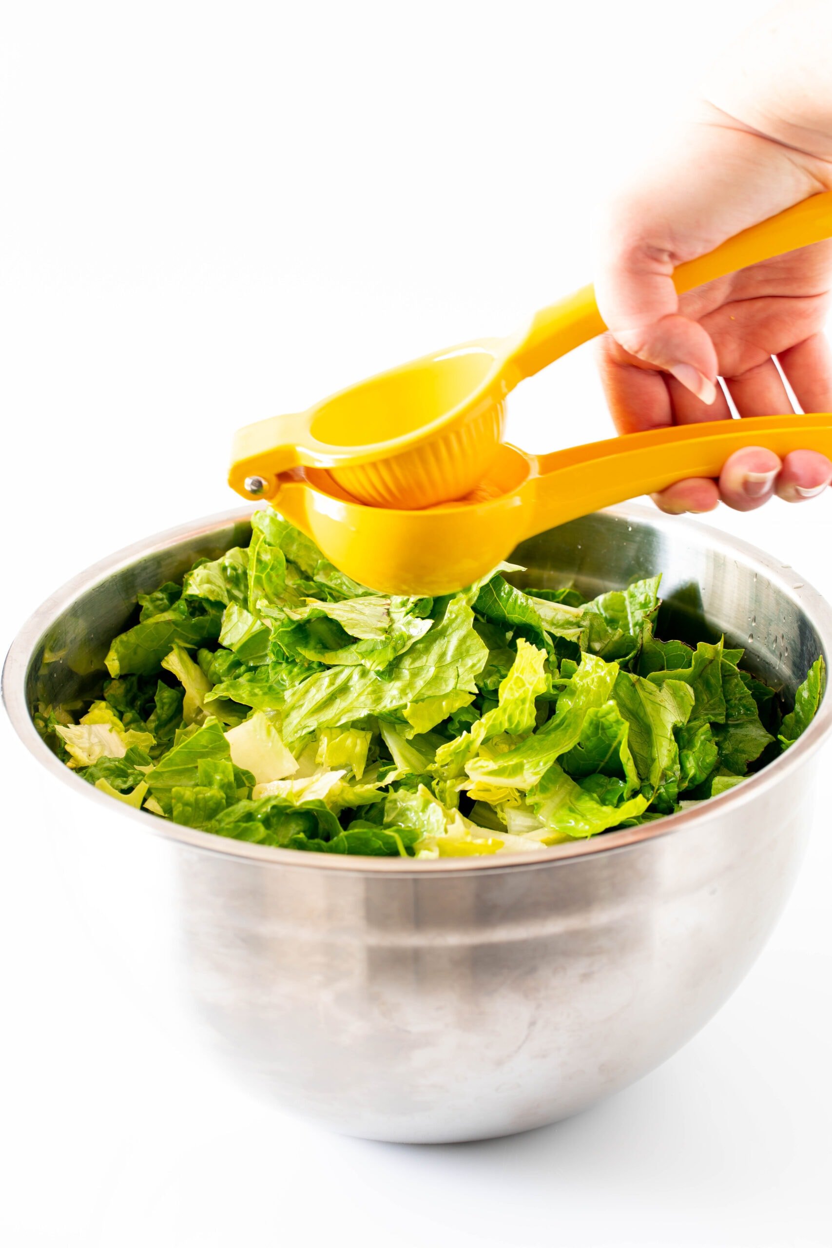 lemon juice being strained over lettuce