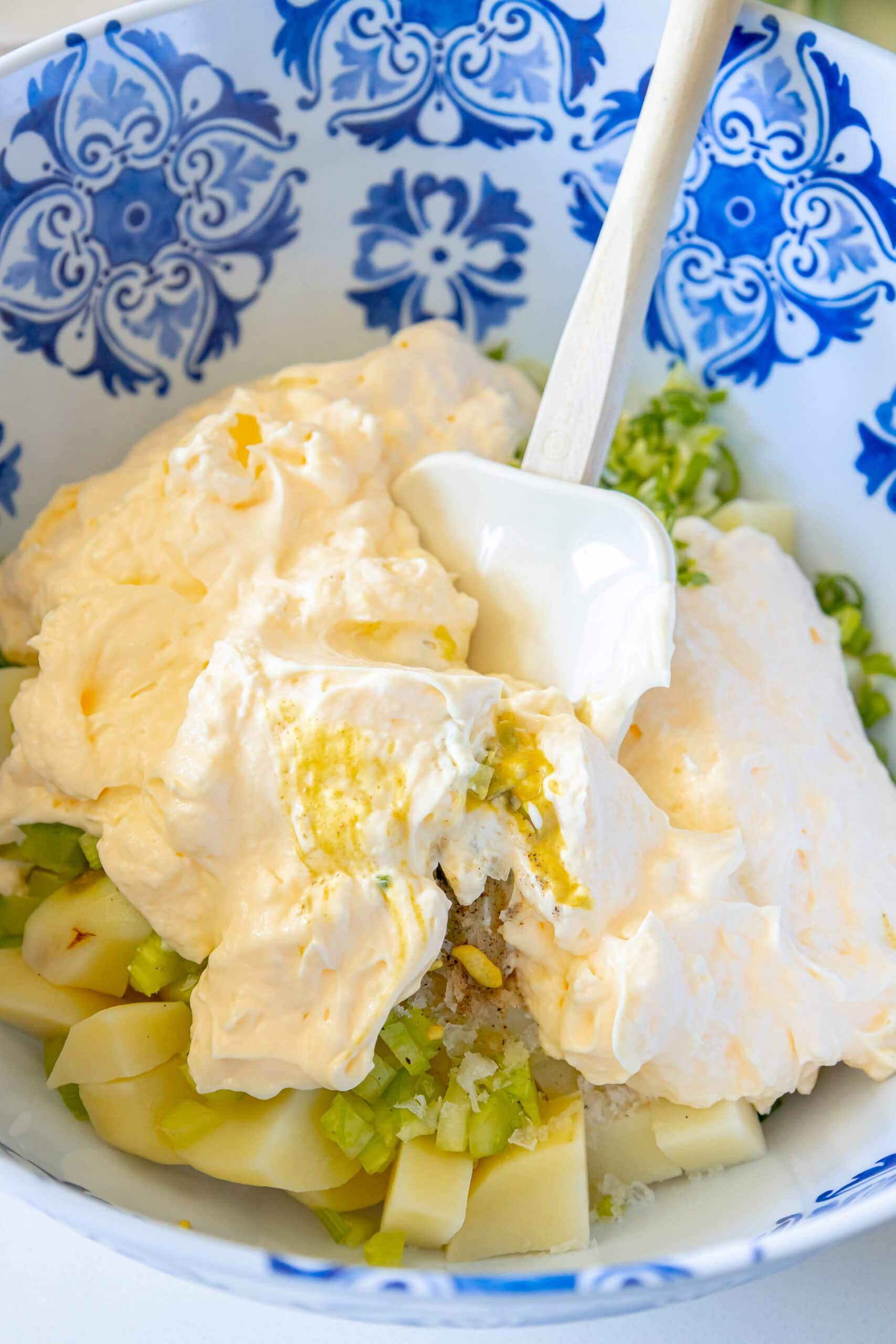 picture of potato salad being mixed in a bowl