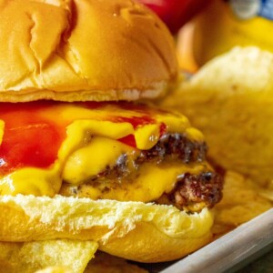 smashburger in a bun with mustard, cheese, and ketchup
