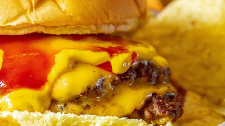 picture of smashburger in a bun with mustard, cheese, and ketchup