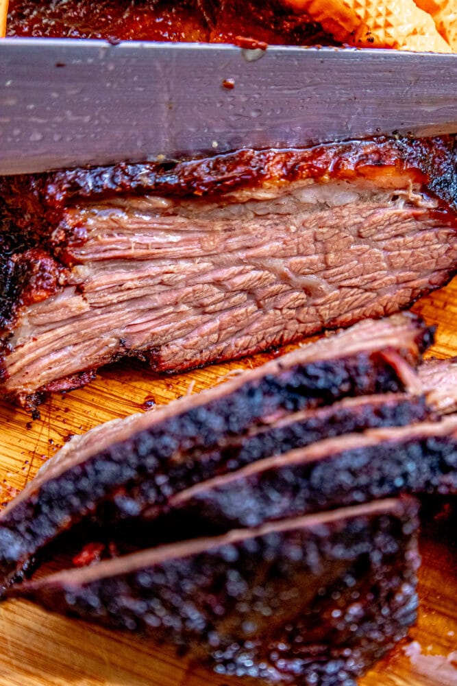 picture of sliced smoked brisket on a wood cutting board