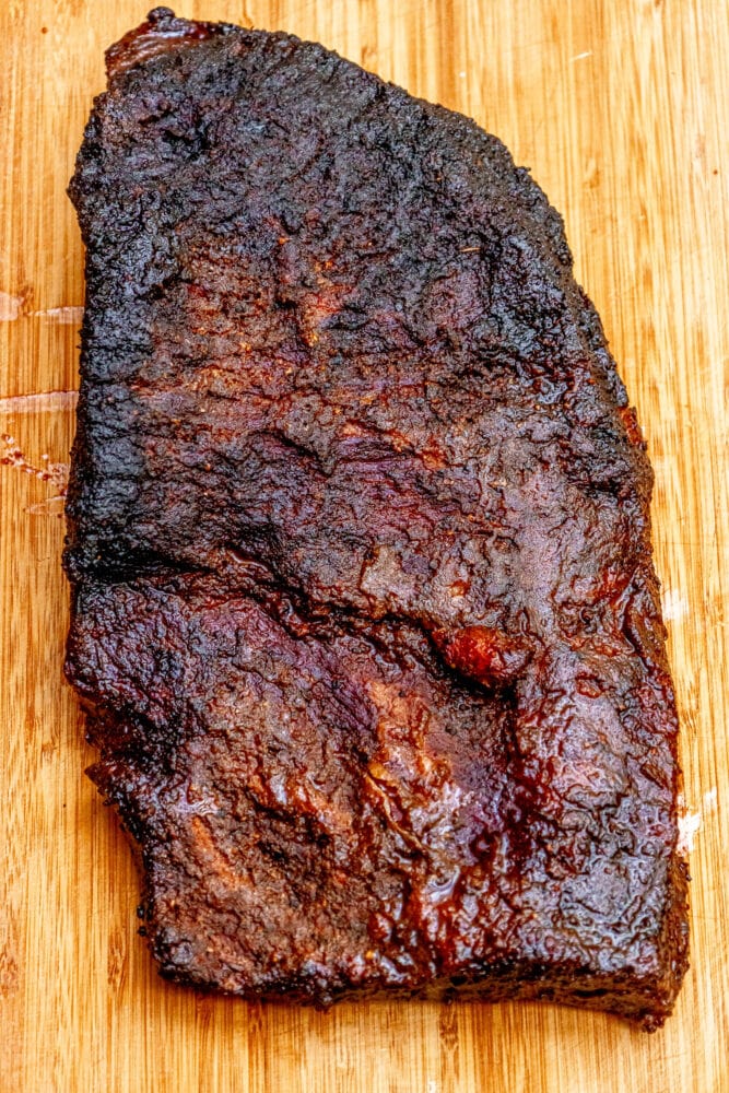 whole smoked brisket on a wood cutting board