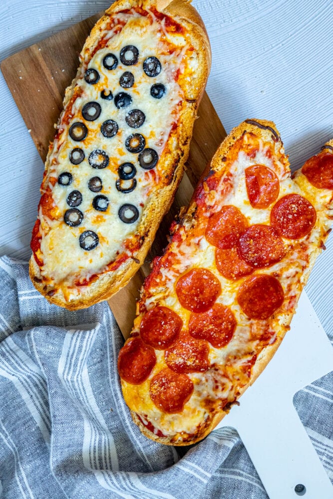 picture of pizza baked on loaves of french bread on a cutting board