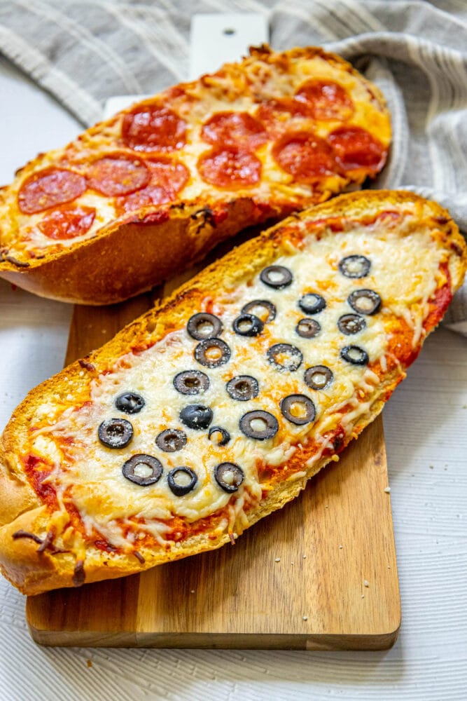 picture of pizza baked on loaves of french bread on a cutting board