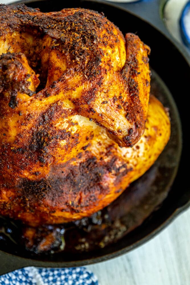 picture of a cooked beer can chicken in a cast iron pan 
