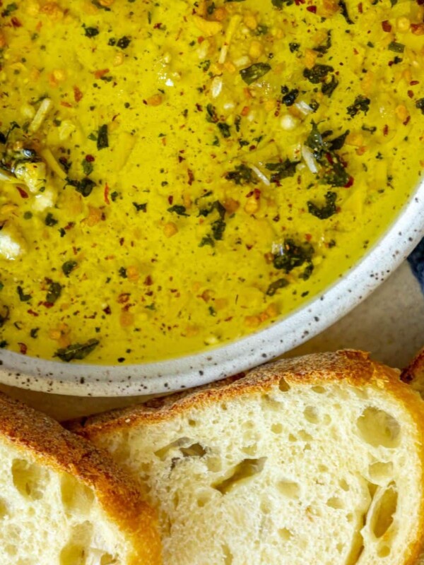 picture of a slice of bread next to a bowl full of olive oil bread dip