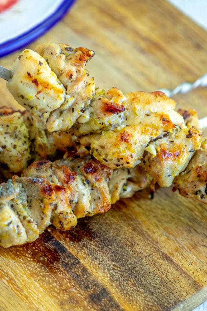 picture of grilled chicken souvlaki on a skewer on a cutting board
