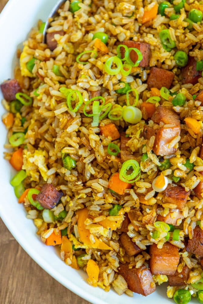 picture of spam fried rice with peppers, peas, and chopped green onions a bowl