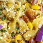 picture of tagliatelle pasta with onion, cilantro, beans, chicken thighs, and cheese