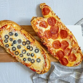 picture of pizza baked on loaves of french bread on a cutting board