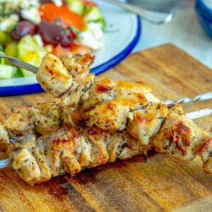 picture of grilled chicken souvlaki on a skewer on a cutting board
