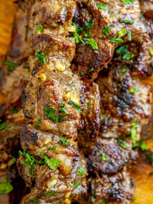 picture of lamb souvlaki on wooden cutting board with chopped cilantro on top